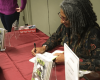 Desiree Cooper signs a book for a student.